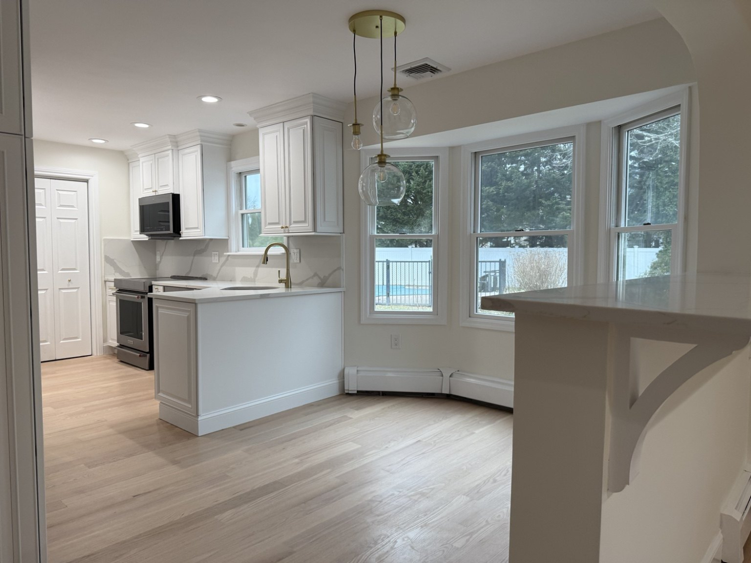 After: Dix Hills kitchen with painted white cabinets, new countertops and hardware in the refreshed kitchen