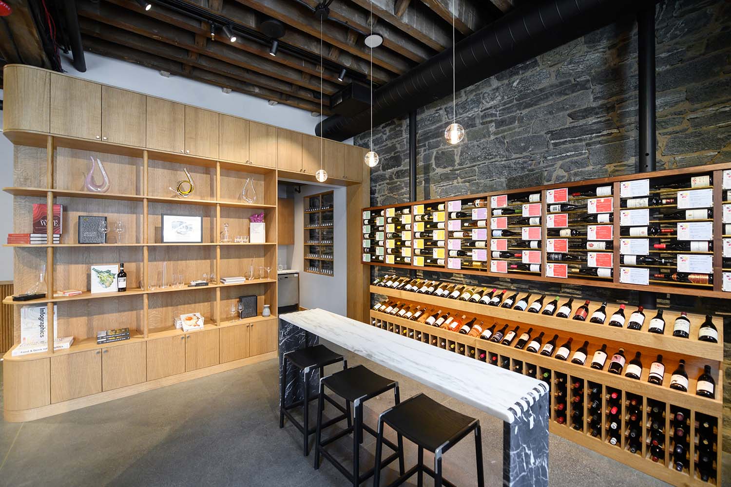 Commercial wine shop interior with custom millwork, stone and lighting