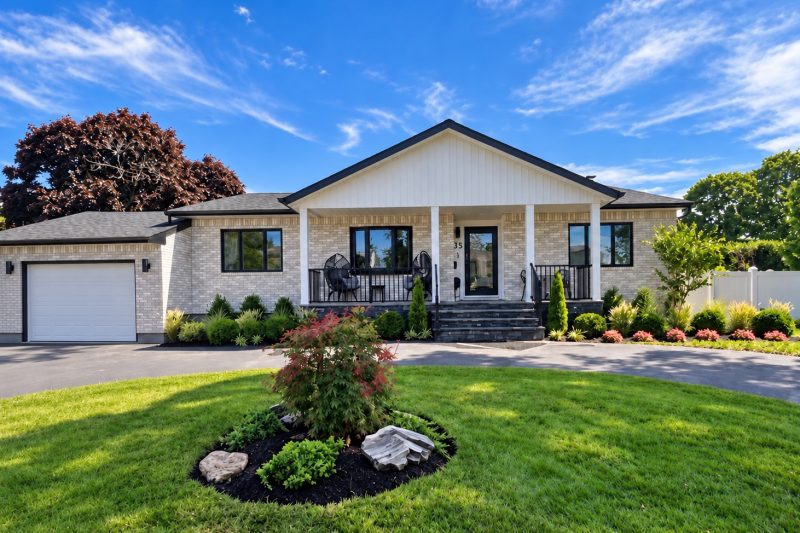 Lindenhurst home with stained brick, a new porch and portico, and front landscaping.
